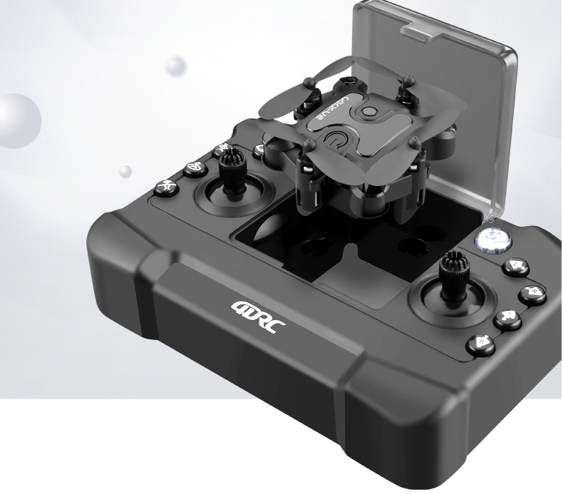 The Dropshipman Mini folding drone, in black, rests atop its matching remote control with multiple buttons and joysticks, set against a light background.