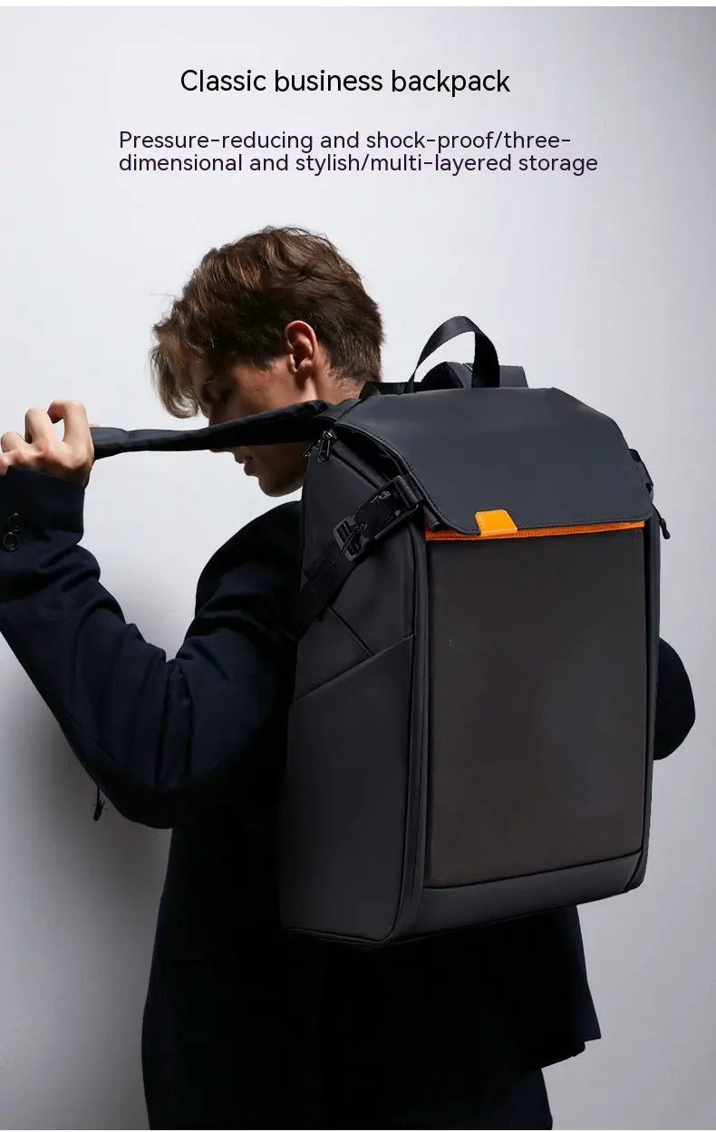 A person in a dark suit wears the Dropshipman Bluetooth Projection Backpack, a black modern bag with orange accents. The plain background highlights its pressure-reduction and multi-layered storage features.