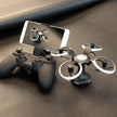 The Dropshipman High-definition Aerial Photography of Drones, in black and silver, sits with its controller and a smartphone streaming a live HD feed—creating a sleek, portable setup on a dark textured surface.