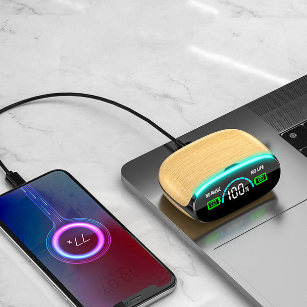 A smartphone charges on a marble surface beside a laptop, connected to Dropshipman’s Wood Grain Wireless Bluetooth Earbuds, which feature a blue-green LED, an LED screen showing "100%" and the message "NO MUSIC NO LIFE.