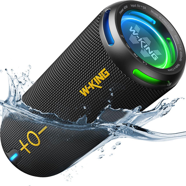 The image shows a portable black Hi-Fi Wireless Bluetooth Stereo by HeadphoneHeat, with immersive surround sound and colorful LED lights. It has a fabric texture, large yellow volume controls, and water splashes around it, indicating it's water-resistant and USB rechargeable.