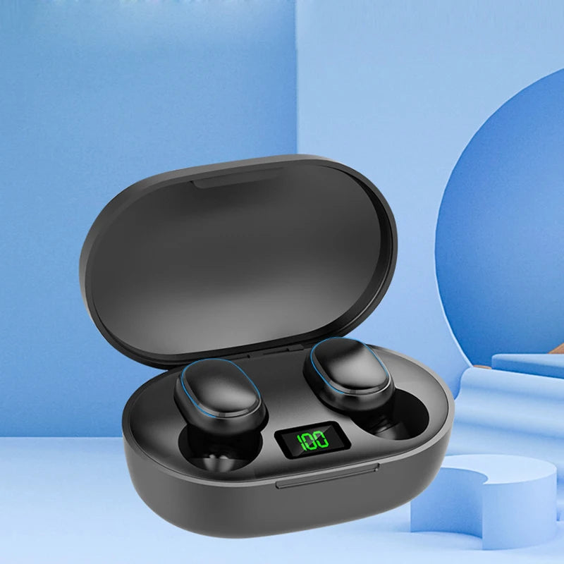 A pair of E7s TWS Earbuds Bluetooth from HeadphoneHeat rests inside an open charging case against a blue, minimalist background. The case features a digital display showing 