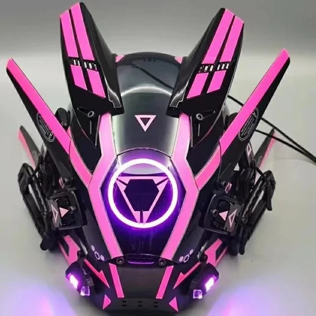 The HeadphoneHeat LED Lights Cyberpunk Full Face Mask features angular designs and glowing pink accents on a sleek black surface, with a central circular emblem illuminated by LED lights, perfect for sci-fi or gaming enthusiasts.