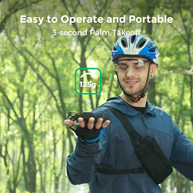 A smiling man in a blue helmet, glasses, and gloves holds the Dropshipman Hover Air X1 Pro 4K drone above his palm in a forest. Text: "Easy to Operate & Portable, 3s Palm Takeoff, Ultralight 125g.