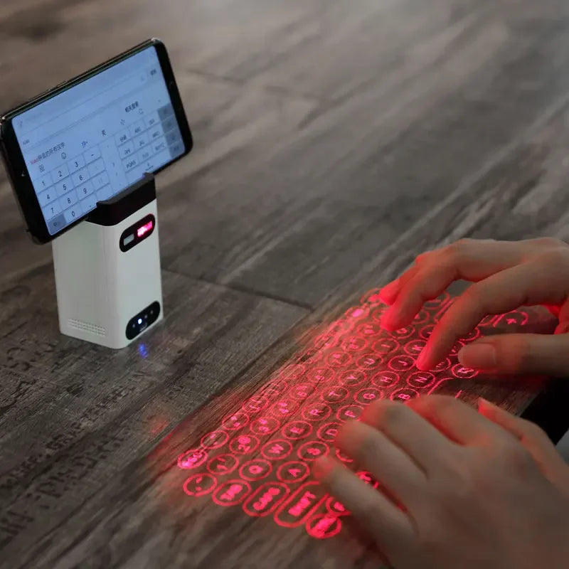 A person types on a red-projected Dropshipman Bluetooth Virtual Laser Keyboard on a wooden table, while their smartphone in a stand displays a calculator app.