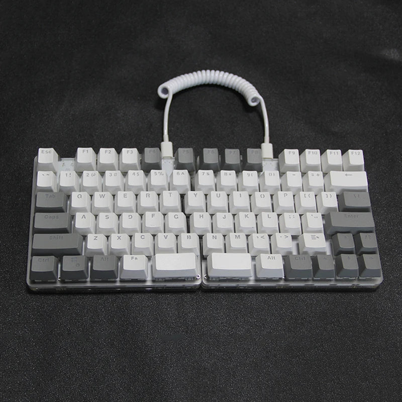 The DEBROGLIE LT78 Split Creative Mechanical Keyboard by HeadphoneHeat sits against a black background, showcasing its grey and white keycaps connected by a coiled cable. It features Kailh switches and an ergonomic design for efficient typing.