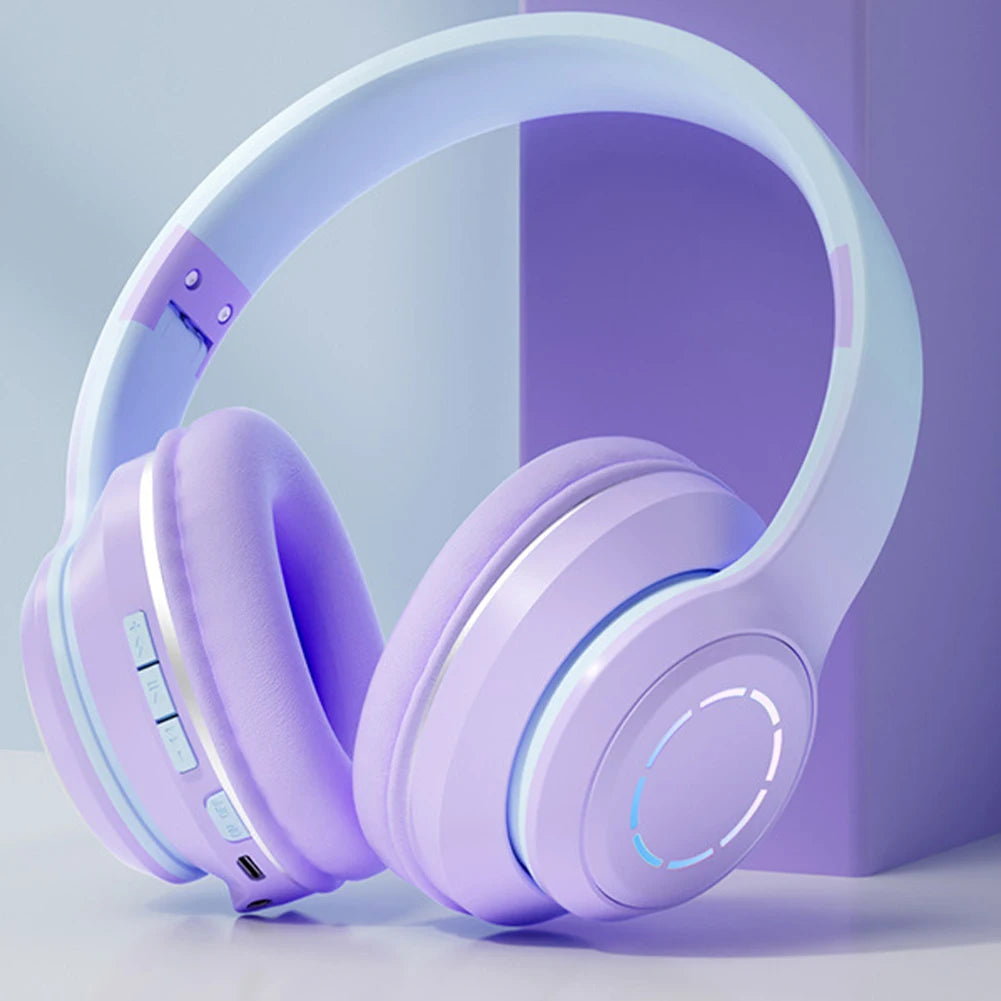 The Wireless HiMISS HiFi Stereo Over Ear Headphones by HeadphoneHeat feature purple ear cushions, a white adjustable headband, control buttons, a charging port on the side, and a softly illuminated circle design on the earcup for superb sound quality like Bluetooth earphones.