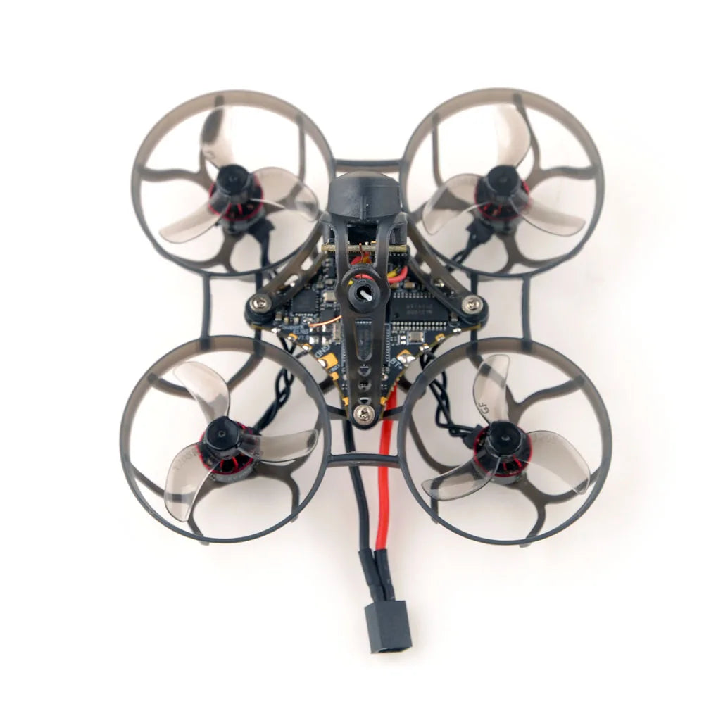 The HeadphoneHeat HappyModel Mobula6 2024 1S 65mm Ultra Light Micro FPV Drone2, featuring ELRS 2.4GHz technology and a SuperX Flight Controller, reveals its sleek design from above with an exposed electronic circuit board against a plain background.