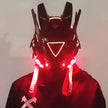A person wears the HeadphoneHeat LED Lights Cyberpunk Full Face Mask with a red LED-lit triangular visor and ear-like protrusions. White 