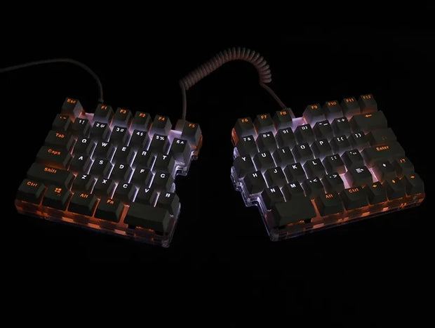 The DEBROGLIE LT78 by HeadphoneHeat is a split, ergonomic mechanical keyboard with Kailh switches and backlit keys on a sleek black background. It features customizable positioning with its coiled cable, and the softly glowing white keys add an elegant touch.