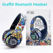 A vibrant, graffiti-themed Bluetooth headset sits beside its box, showcasing lively abstract artwork. The packaging prominently features 