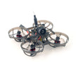 The HappyModel Mobula6 2024 1S 65mm Ultra Light Micro FPV Drone2, from HeadphoneHeat, is a compact quadcopter featuring circular guards around its four propellers. It includes a SuperX Flight Controller and a central camera, operating on the ELRS 2.4GHz frequency for smooth control, against a plain white background.