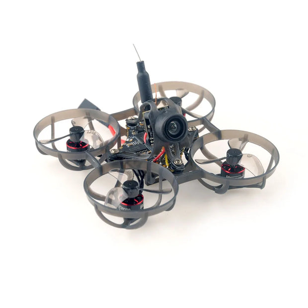 The HappyModel Mobula6 2024 1S 65mm Ultra Light Micro FPV Drone2, from HeadphoneHeat, is a compact quadcopter featuring circular guards around its four propellers. It includes a SuperX Flight Controller and a central camera, operating on the ELRS 2.4GHz frequency for smooth control, against a plain white background.