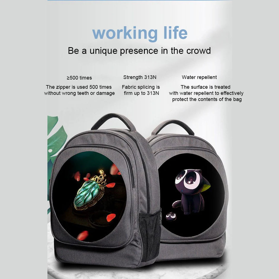 Two grey BSIDE 3D Holographic Projector Backpacks by HeadphoneHeat are displayed side by side against a light background. Each backpack features a circular design on the front; one showcases an image of an insect on a flower, while the other depicts a cartoon animal. Text above highlights features such as durability, water repellency, and certified quality.