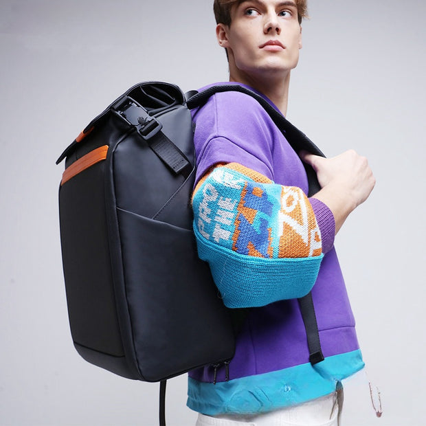A young man wearing a purple and blue sweater carries the Dropshipman Bluetooth Projection Backpack over one shoulder, looking off to the side against a plain light background.