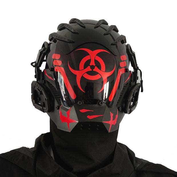 A person wears the Dropshipman Bioweapon Tech Mask, a full-face party helmet with angular red designs and a red biohazard symbol. This futuristic accessory features side attachments and is styled with sleek black clothing.