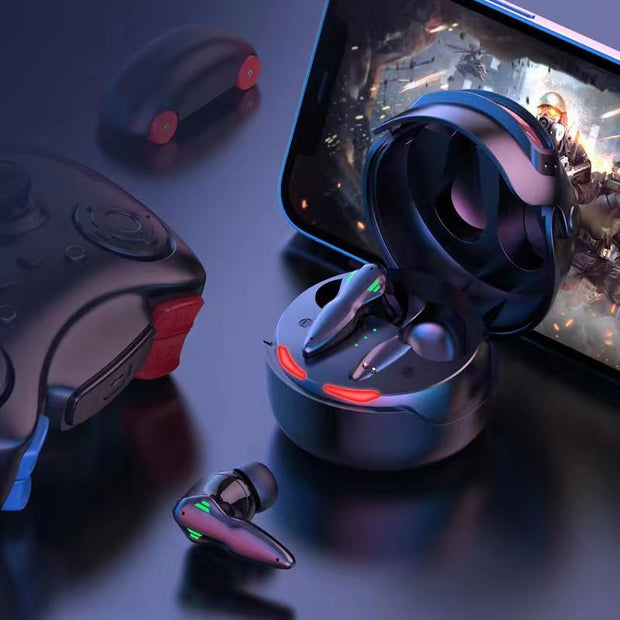The Dropshipman Fortipod Earbuds in their charging case are shown next to a smartphone with a video game and a controller, all on a dark surface with blue and red lighting—an ideal esports headset setup.