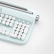A close-up of the Dropshipman Tablet Phone Wireless Bluetooth Typewriter, featuring white rounded keys and a vintage typewriter design in light blue, set against a plain white background.